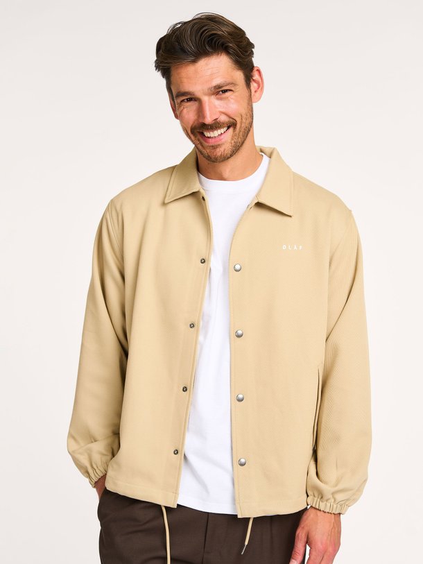Ontdek de Coach geweven logo jack van OLAF in de kleur beige bij Orangebag. Op werkdagen voor 21:45 besteld, morgen in huis.