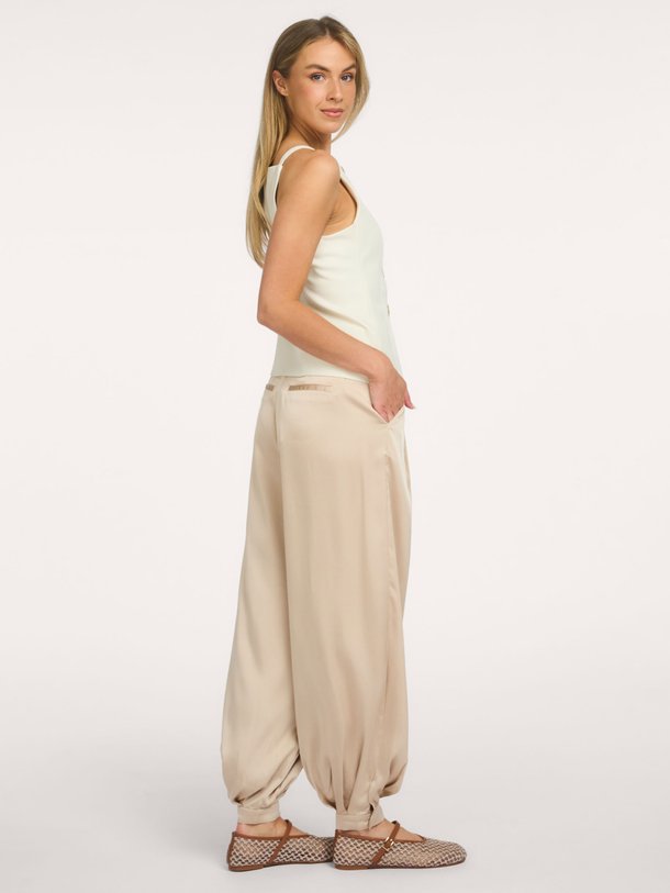 Ontdek de Fayla Drapy Satin Balloon Pants van Neo Noir bij Orangebag. Een elegante champagnekleurige broek met een luxe glans en een trendy balloon fit.