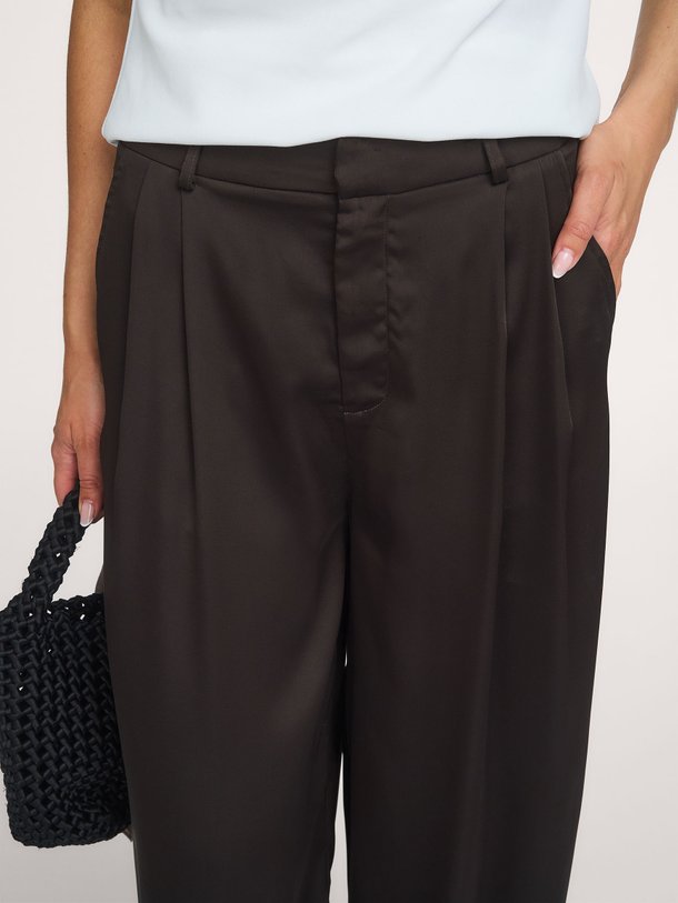 Ontdek de Fayla Drapy Satin Balloon Pants van Neo Noir bij Orangebag. Een stijlvolle donkerbruine broek met een luxe glans en trendy barrel fit.