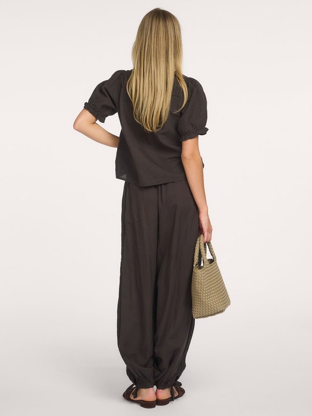 Shop de Neo Noir Odesa Linen Blouse bij Orangebag. Een tijdloze zwarte top met elegante pofmouwen en een flatterende V-hals. Perfect voor elke gelegenheid.