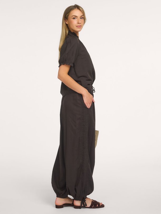 Shop de Neo Noir Odesa Linen Blouse bij Orangebag. Een tijdloze zwarte top met elegante pofmouwen en een flatterende V-hals. Perfect voor elke gelegenheid.