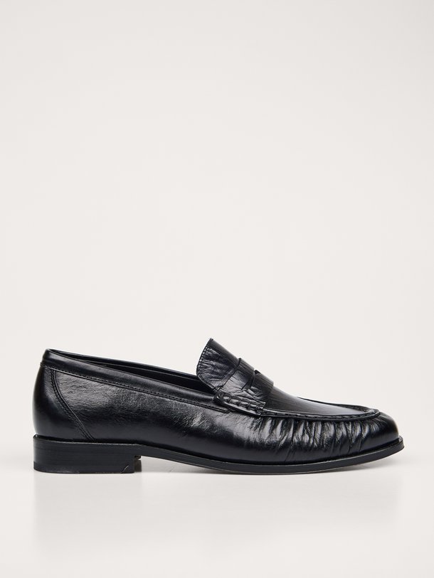 Ontdek de Posa Penny Loafer Wrinkle in zwart leer bij Orangebag. Een tijdloze klassieker met een uniek rimpel-effect voor een moderne, stijlvolle twist.