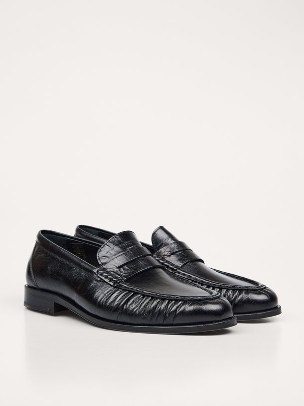 Ontdek de Posa Penny Loafer Wrinkle in zwart leer bij Orangebag. Een tijdloze klassieker met een uniek rimpel-effect voor een moderne, stijlvolle twist.
